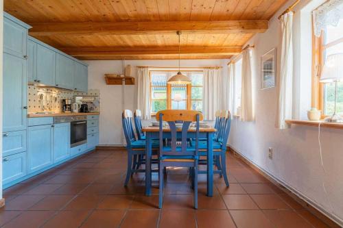 una cucina con tavolo e sedie blu di Haushaelfte Pigead s Cove ID 428 a Tönning