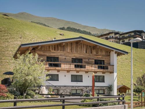 a wooden building with a balcony on a hill at Ferienhaus Evelyn in Tux
