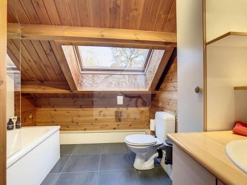 a bathroom with a toilet and a sink and a window at La cabane du Cerf in Stavelot