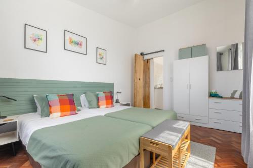 a bedroom with a large bed with colorful pillows at Coastal São Vicente Mountain & Sea View Hideaway with Free Parking in São Vicente