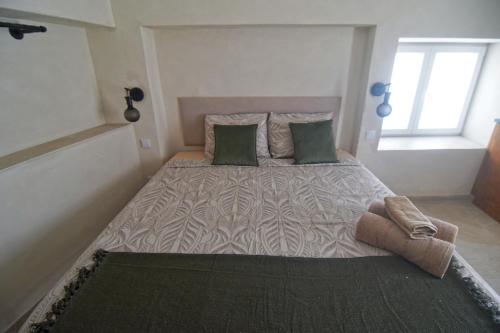 una camera da letto con un letto grande con cuscini verdi di Vista do Alentejo Rooftop at House near the lake a Torrão