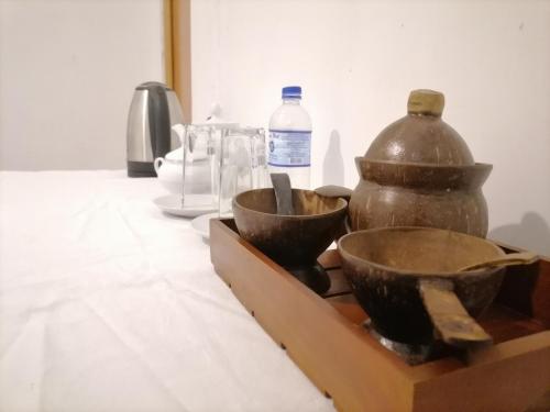 a table with two bowls and a jug on it at Ella Mountain Inn in Ella