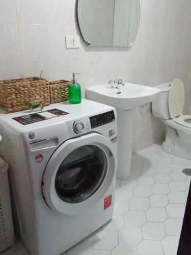 a washing machine in a bathroom with a sink at Piso Sol y Mar vacacional in Moaña