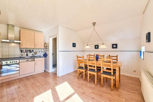 a kitchen and dining room with a table and chairs at Reetdachhaus Suensbarg in Simonsberg