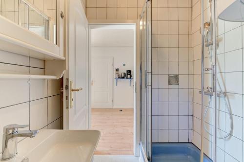 a bathroom with a shower and a sink at Reetdachhaus Suensbarg in Simonsberg