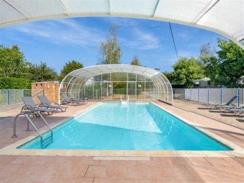 a swimming pool with a glass house and chairs at Camping 3 étoiles - Piscine - ccbb0be in Ambon