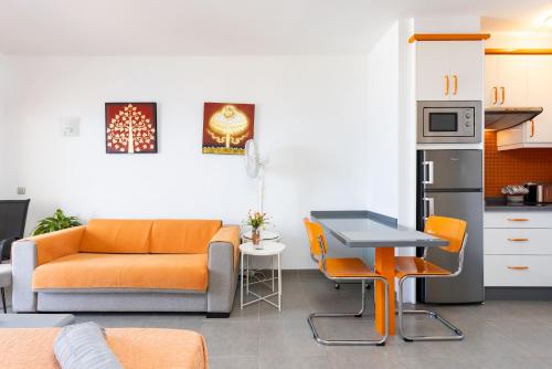 ein Wohnzimmer mit Sofa und Tisch in der Unterkunft Home2Book Relaxing Coastal Studio in Adeje in Adeje
