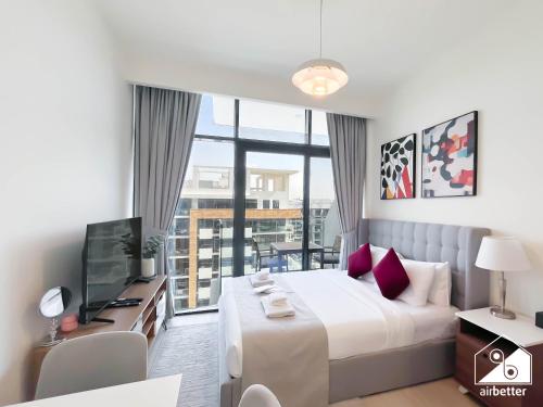 Un dormitorio con una cama grande y un televisor. en Amazing Studio in Meydan l Pool , Gym & Balcony, en Dubái