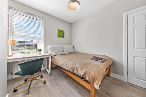 a bedroom with a bed and a desk and a chair at Tranquil 2 Bedroom Rose Cottage near Stratford in London
