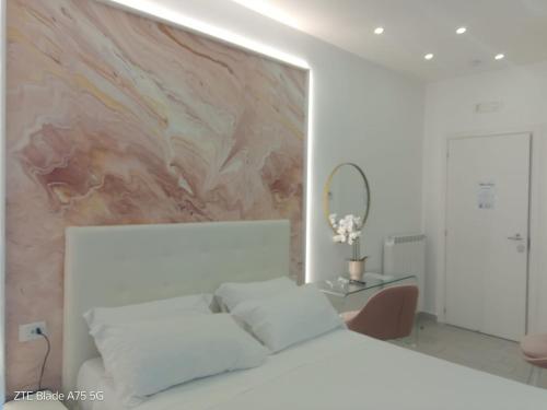 a bedroom with a white bed and a painting on the wall at Maison De luxe in Pompei