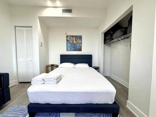 a bedroom with a white bed with towels on it at MetroPark Hotel in Miami