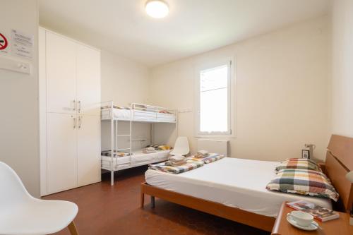 a small white bedroom with a bed and a chair at BBConegliano Bixio in Conegliano