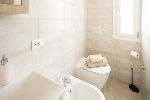 a white bathroom with a toilet and a sink at BBConegliano Bixio in Conegliano