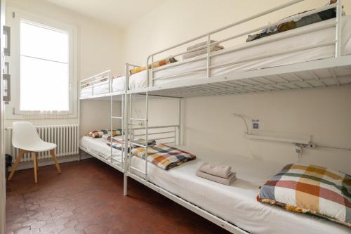a bedroom with two bunk beds and a chair at BBConegliano Bixio in Conegliano
