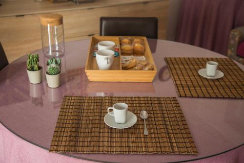 a table with coffee cups and a box of donuts at Casa del Jazz Historical Center in Piazza Armerina