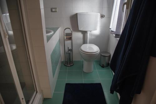 a bathroom with a toilet and a green floor at Casa del Jazz Historical Center in Piazza Armerina