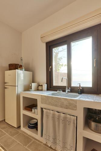 a kitchen with a sink and a refrigerator at The Light House Chorefto in Chorefto