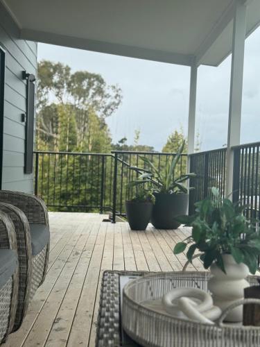 a patio with chairs and tables on a deck at Distant Ocean View central bfast included in Charlestown