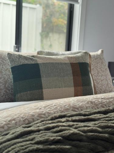 a bed with a blanket and two pillows on it at Distant Ocean View central bfast included in Charlestown