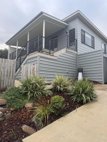 a gray house with a balcony and some plants at Distant Ocean View central bfast included in Charlestown
