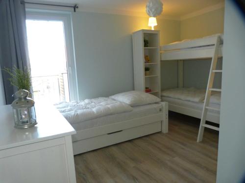 a bedroom with two bunk beds and a window at Ferienwohnung Residenz Erik in Rerik