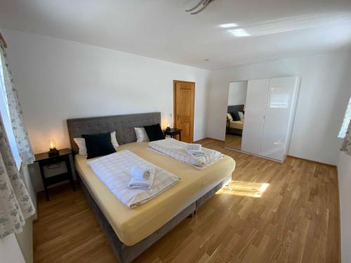 a bedroom with a large bed with towels on it at Traumferienwohnungen Schliersee in Schliersee