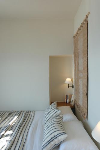 a bed with two pillows on it in a bedroom at Mnimes Guesthouses Santorini in Fira