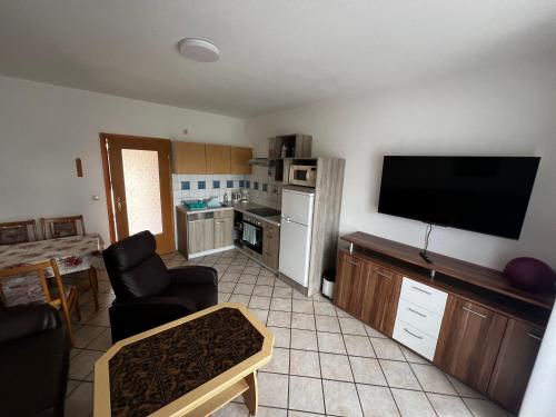 a living room with a flat screen tv and a kitchen at Wiedemann Heiko in Mellenthin