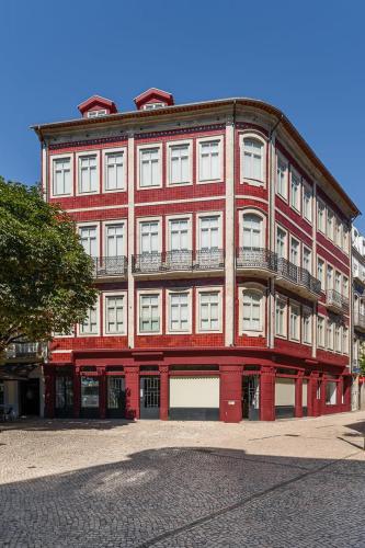 a large red brick building with balconies on it at GuestReady - AMMA Braga Apartments in Braga