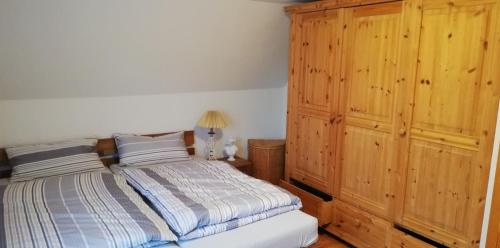 a bedroom with a bed and a wooden cabinet at Ferienwohnung Paula in Buxtehude