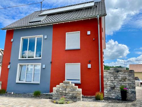 a red house with a gray roof at Haus Lotusblüte in Kelberg