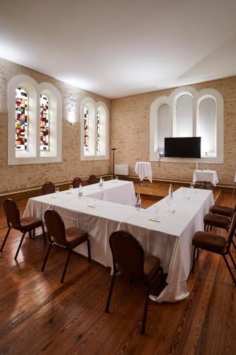 a large room with a large white table and chairs at Hôtel Restaurants & Spa Perier Du Bignon in Laval