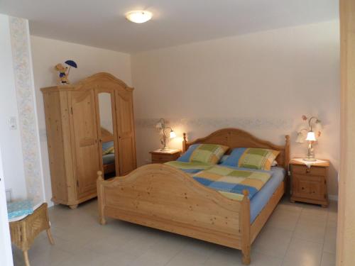 a bedroom with a wooden bed and two night stands at Haus Sonnenhof am Dollart 45240 in Ditzumerhammrich