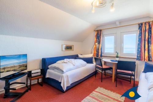 a bedroom with a bed and a desk and a tv at Strandvilla DG in Bansin