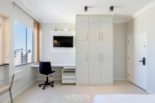 a white bedroom with a desk and a chair at Estúdio Completo em Curitiba EDA0001 in Curitiba
