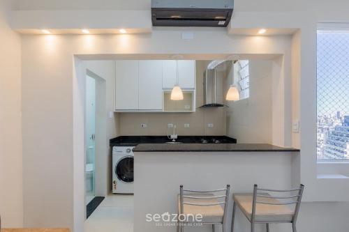 a kitchen with a counter and a washer and dryer at Estúdio Completo em Curitiba EDA0001 in Curitiba