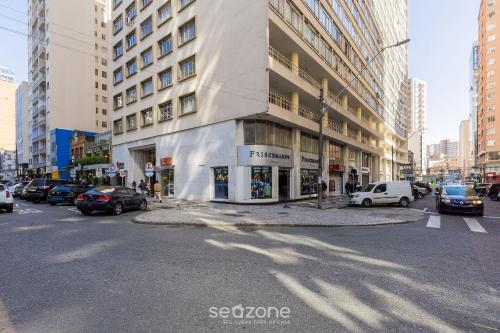 a city street with cars parked in front of a building at Estúdio Completo em Curitiba EDA0001 in Curitiba