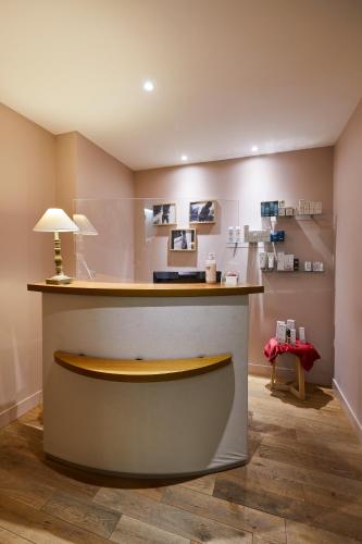 a bar in a room with a counter and a table at Hôtel Restaurants & Spa Perier Du Bignon in Laval
