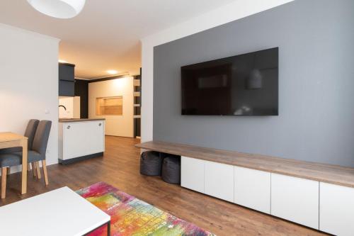 a living room with a flat screen tv on a wall at City Apartment Riesa in Riesa