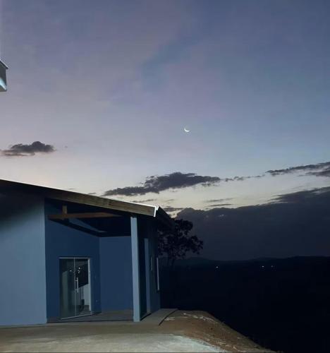 a blue house with a view of the sky at Bangalô do Recanto dos Lagos in Caconde