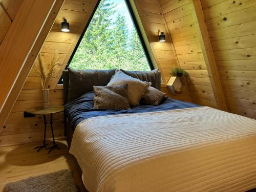 a bed in a room with a large window at Hygge villa in Žabljak