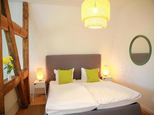 a bedroom with a bed with two lime green pillows at Gut Boltenhof in Fürstenberg-Havel