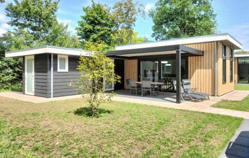 a small shed with a table and chairs in a yard at Awesome Home In Voorthuizen in Voorthuizen
