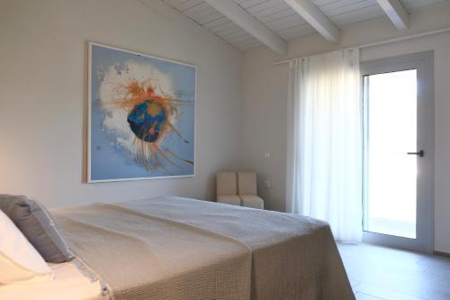 a bedroom with a bed and a painting on the wall at Evia Bay Suites and Retreats in Edipsos