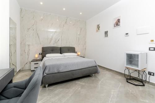 a bedroom with a large bed and a television at Nova Suite in Catania