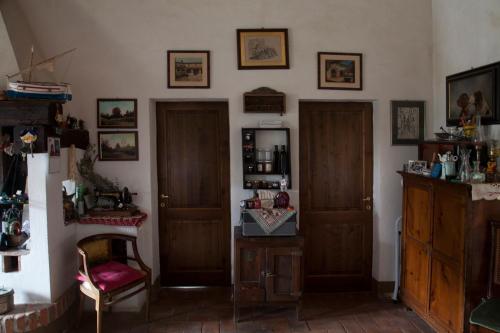 a living room with two doors and a chair at Agriturismo Santa Maria in Torrita di Siena
