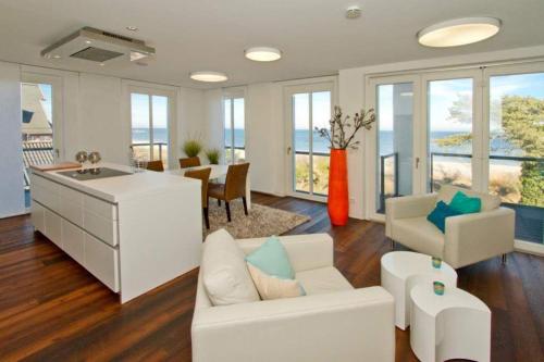ein Wohnzimmer mit einer weißen Couch und einem Tisch in der Unterkunft Strandresidenzen Bansin, Ostseepalais 08 in Bansin