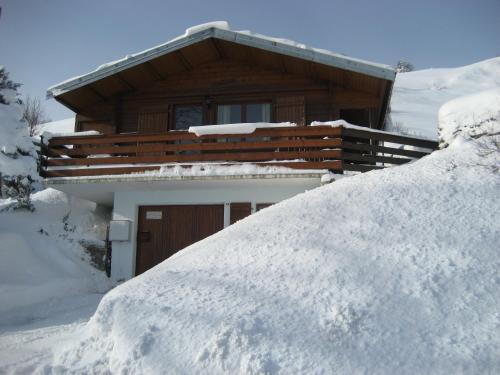 une pile de neige devant une maison dans l'établissement Chalet Les Jonquilles, à La Bresse