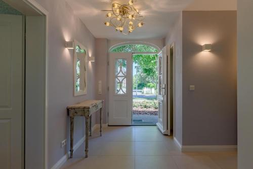 a hallway with a door and a chandelier at Landhaus unter den Linden in Nieblum