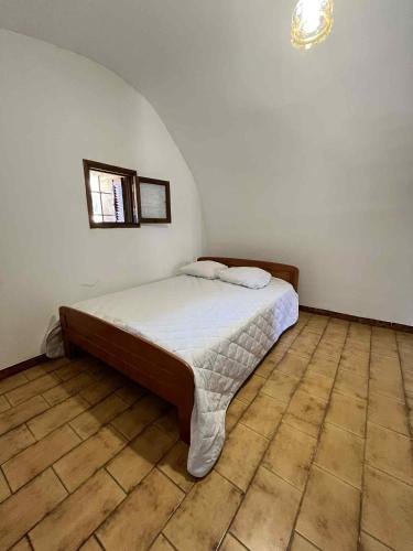 une chambre avec un lit dans le coin d'une pièce dans l'établissement Appartement de village proche de la plage, à Aregno